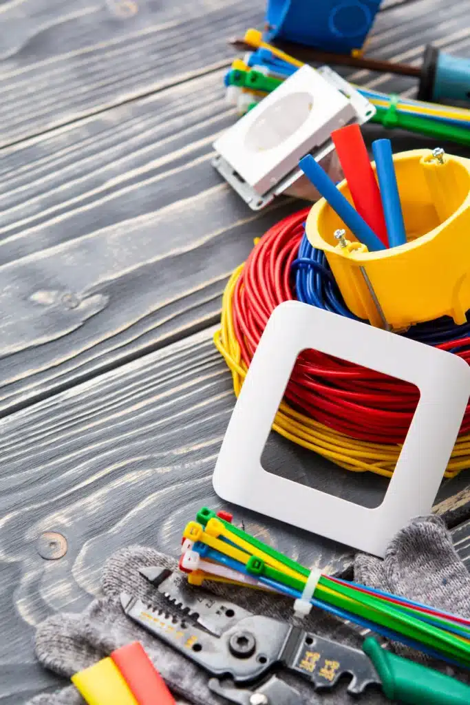 Matériel d'installation électrique comprenant des fils colorés, un boîtier de prise, des outils de coupe et des accessoires pour le câblage. ​