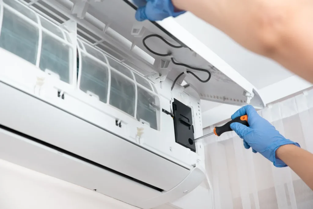 Intervention de dépannage sur un climatiseur intérieur, démontage des filtres pour réparation.